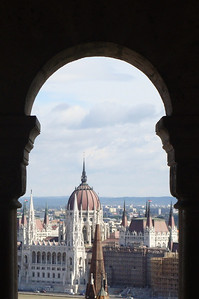 the parliament building through an arch at the Fishermen's Bastion