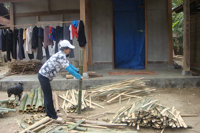 a woman making a bamboo fence