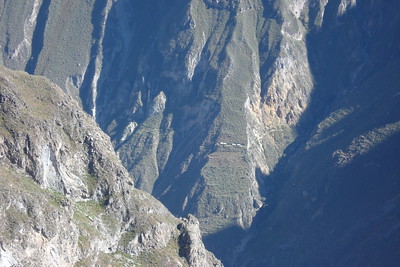 small storage houses on a path that cuts through the canyon