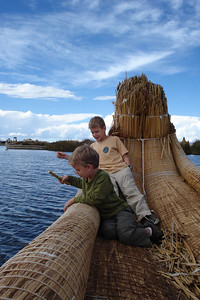 the boys were dragging their little reed boat alongside a real one