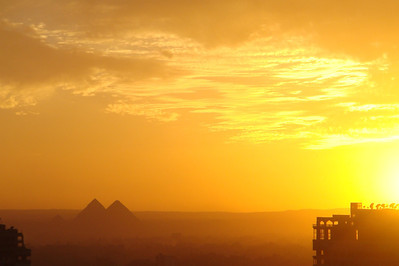 a view  from our hotel of the sun setting behind the pyramids