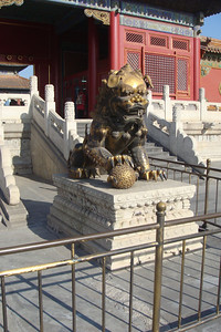 many buildings have twin lion statues, the male holding a ball...