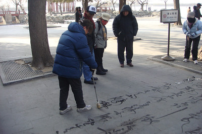 a woman writing Chinese with water that would immediately freeze