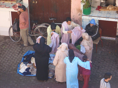 a group of women bargaining for some blankets